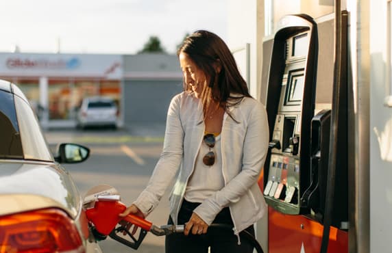 Une femme fait le plein à une station Petro-Canada.